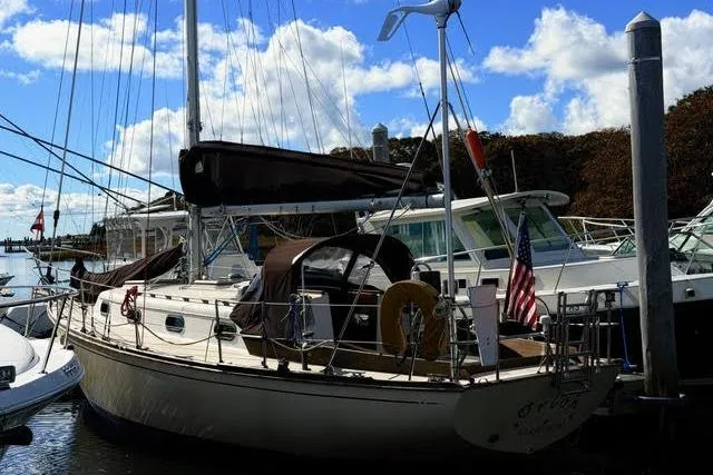 Slide: The Image of 1985 Cape Dory Cutter sailboat docked at marina under blue sky. - 3