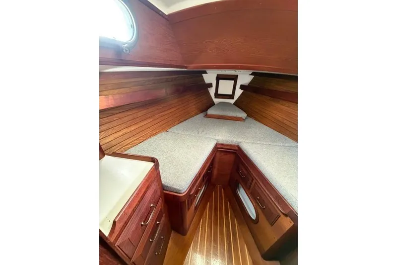 Slide: The Image of 1985 Cape Dory Cutter cabin interior with wood paneling and cozy sleeping area. - 7