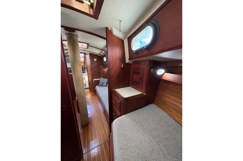 Slide: The Image of 1985 Cape Dory Cutter interior with wooden finish and cozy sleeping area. - 9