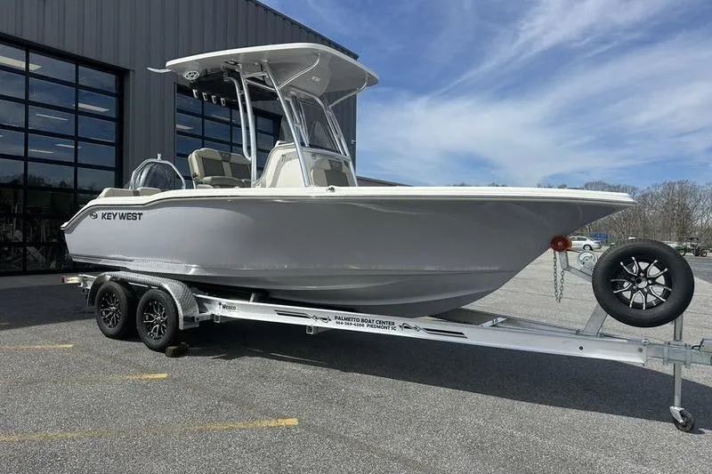 The Image of 2026 Key West 219 FS boat on trailer, parked outdoors near a building. - 1
