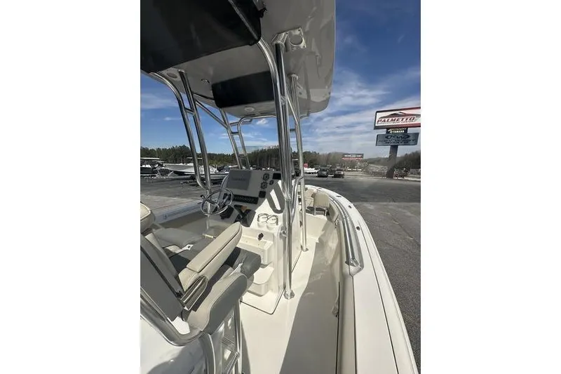 Slide: The Image of 2026 Key West 219 FS boat interior with steering console and seating, parked outdoors. - 10