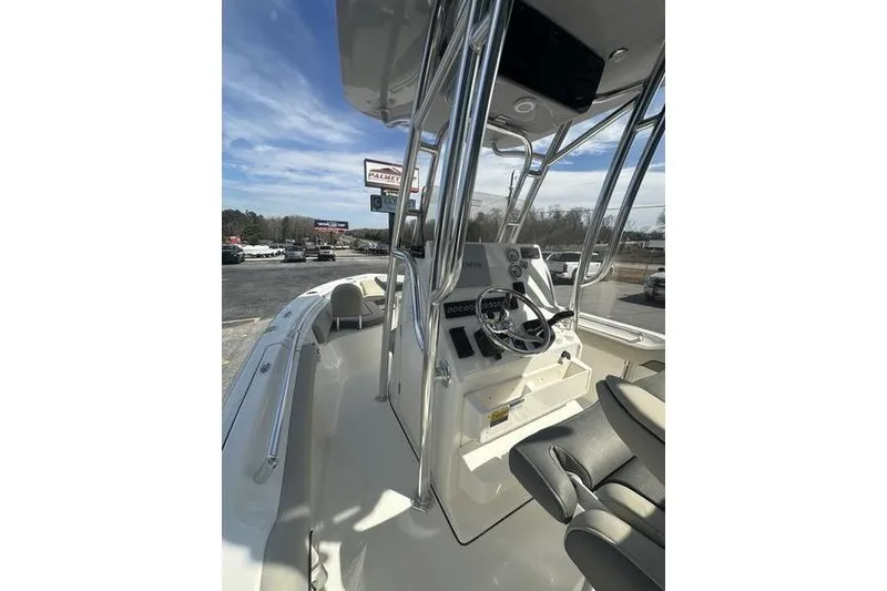 Slide: The Image of 2026 Key West 219 FS boat interior with steering console and seating under clear sky. - 17