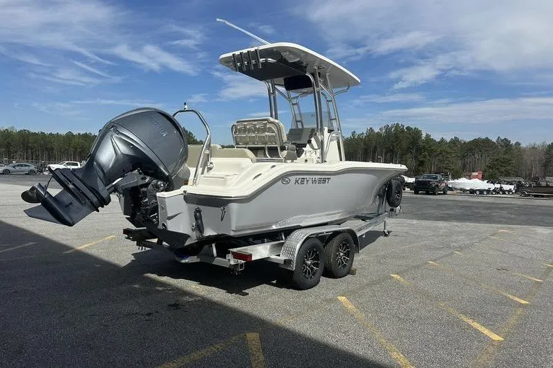 Slide: The Image of 2026 Key West 219 FS boat on trailer, parked outdoors under clear sky. - 4