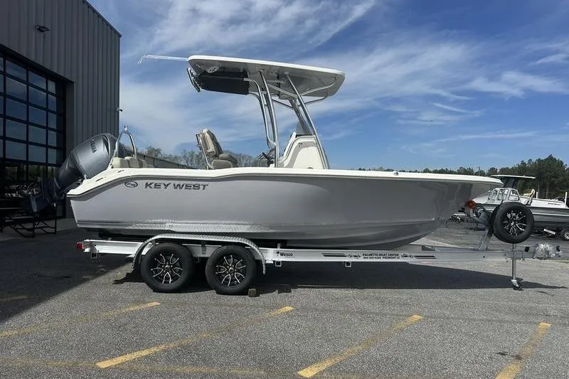 Slide: The Image of 2026 Key West 219 FS boat on trailer, parked outdoors under blue sky. - 5