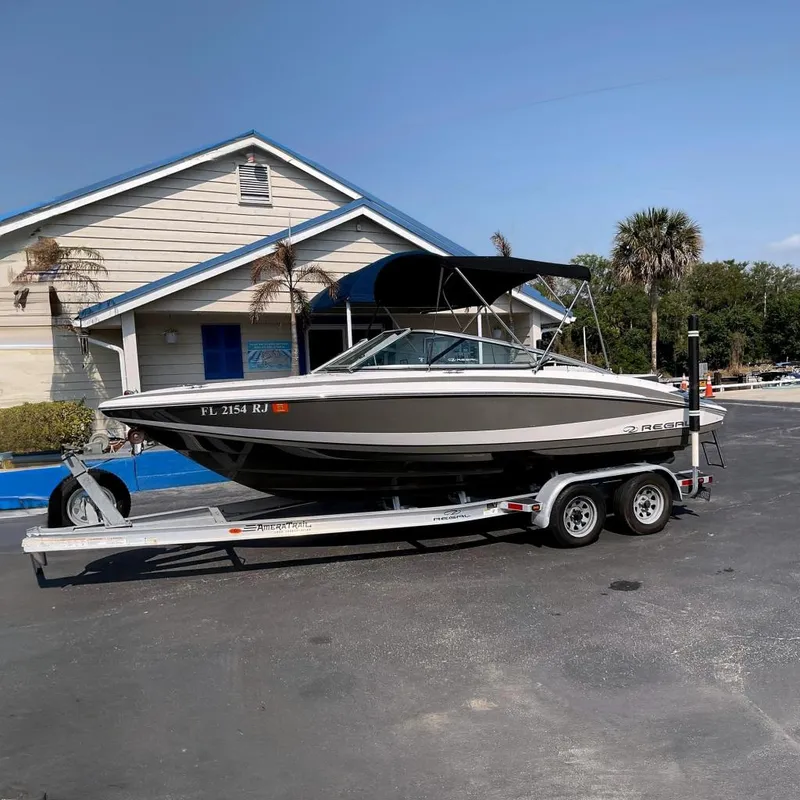 The Image of 2015 Regal 2100 Bowrider on trailer in front of building. - 0