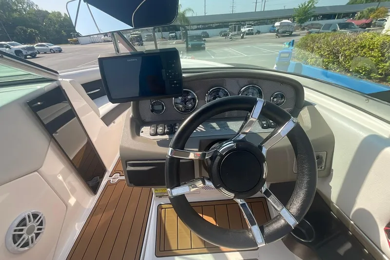 Slide: The Image of 2015 Regal 2100 Bowrider dashboard with steering wheel and navigation display. - 12