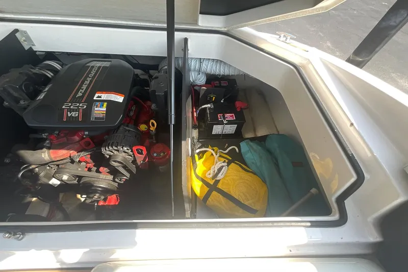 Slide: The Image of Engine compartment of a 2015 Regal 2100 Bowrider with storage items. - 17