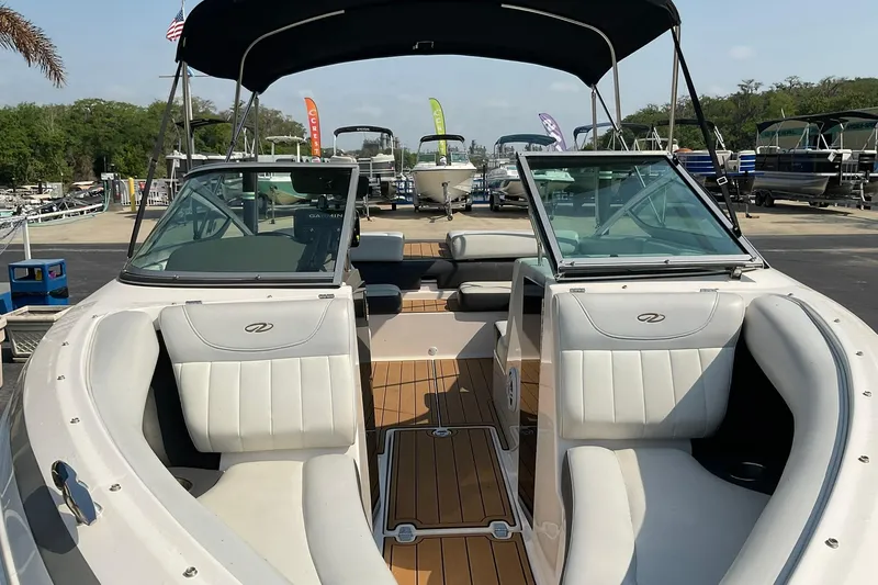 Slide: The Image of 2015 Regal 2100 Bowrider boat with open seating and canopy at a marina. - 8