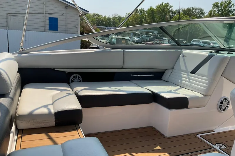 Slide: The Image of 2015 Regal 2100 Bowrider interior with white seating and wood flooring. - 9