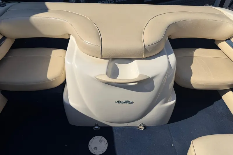 Slide: The Image of 2001 Sea Ray 210 Bow Rider interior with beige seating and blue carpet. - 10