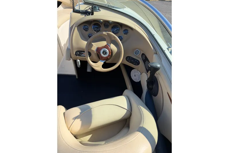 Slide: The Image of 2001 Sea Ray 210 Bow Rider cockpit with beige interior and steering wheel. - 11