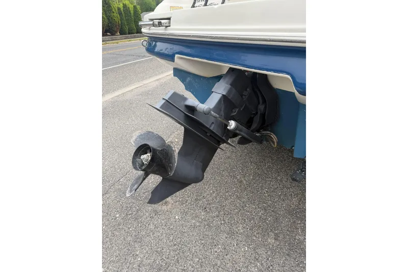 Slide: The Image of 2001 Sea Ray 210 Bow Rider boat stern with propeller on pavement. - 4