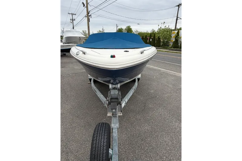 Slide: The Image of 2001 Sea Ray 210 Bow Rider on trailer, covered, parked on roadside. - 5