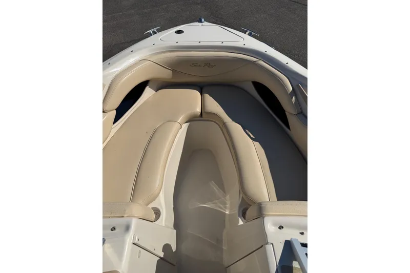 Slide: The Image of 2001 Sea Ray 210 Bow Rider boat interior with beige seating and sleek design. - 7