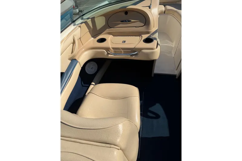 Slide: The Image of Interior of a 2001 Sea Ray 210 Bow Rider boat, featuring beige seating and dashboard. - 8