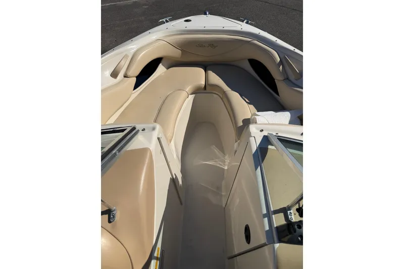 Slide: The Image of 2001 Sea Ray 210 Bow Rider interior with beige seating and open bow area. - 9