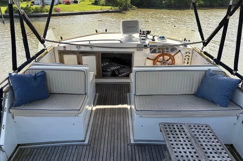 Slide: The Image of 1986 Grand Banks 42 Classic yacht interior with seating, wooden deck, and steering wheel. - 13