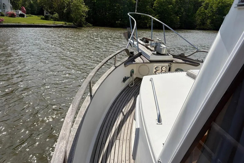 Slide: The Image of 1986 Grand Banks 42 Classic yacht on a serene river, surrounded by lush greenery. - 19