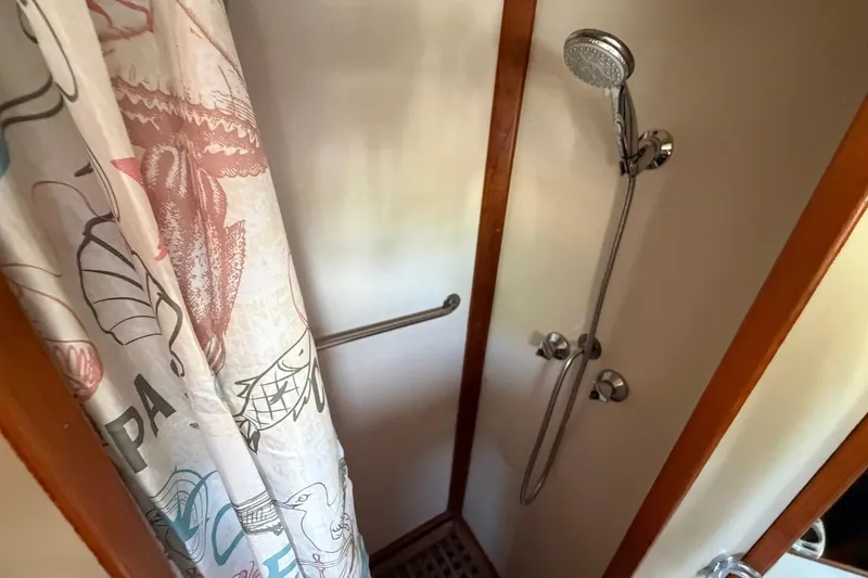 Slide: The Image of Shower area in 1986 Grand Banks 42 Classic boat with nautical-themed curtain. - 39