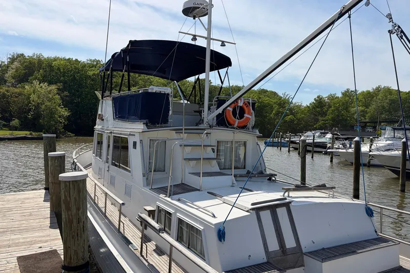 Slide: The Image of 1986 Grand Banks 42 Classic yacht docked at a marina, featuring a spacious deck and canopy. - 8