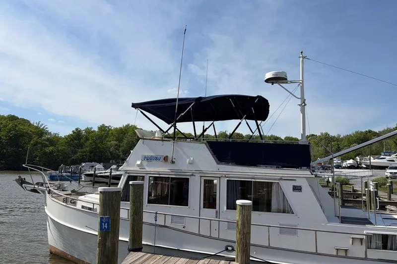 Slide: The Image of 1986 Grand Banks 42 Classic yacht docked at a marina under a clear blue sky. - 9