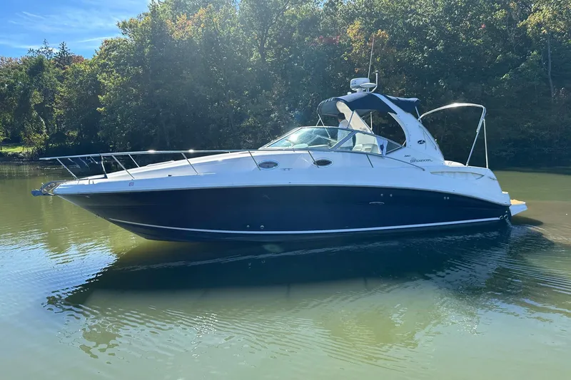 The Image of 2005 Sea Ray 320 Sundancer boat on calm water, surrounded by trees. - 0