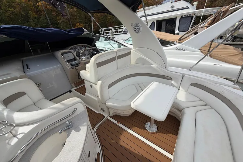 Slide: The Image of 2005 Sea Ray 320 Sundancer interior with white seating and wooden flooring. - 11