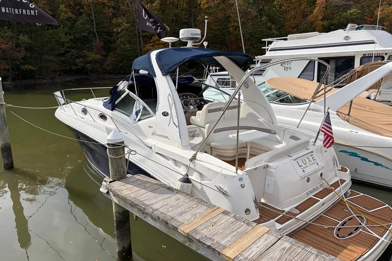 Slide: The Image of 2005 Sea Ray 320 Sundancer docked, featuring sleek design and American flag. - 13