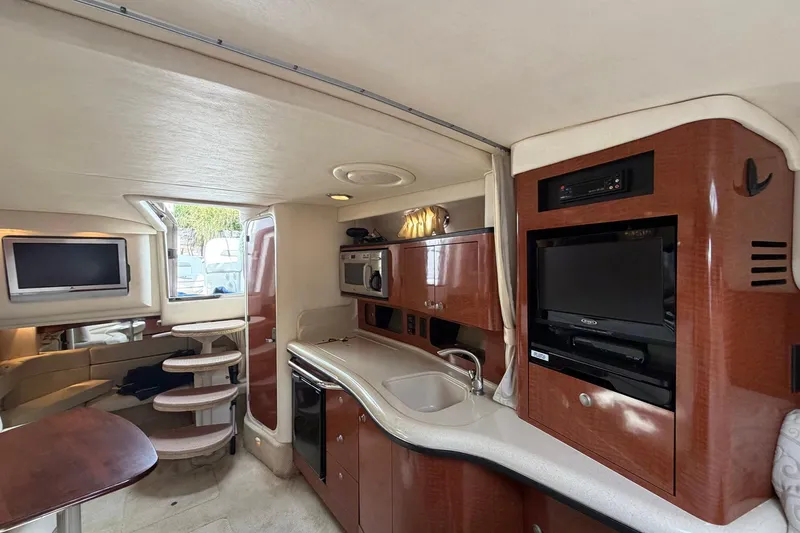 Slide: The Image of Interior of 2005 Sea Ray 320 Sundancer yacht with kitchen, TV, and seating area. - 3