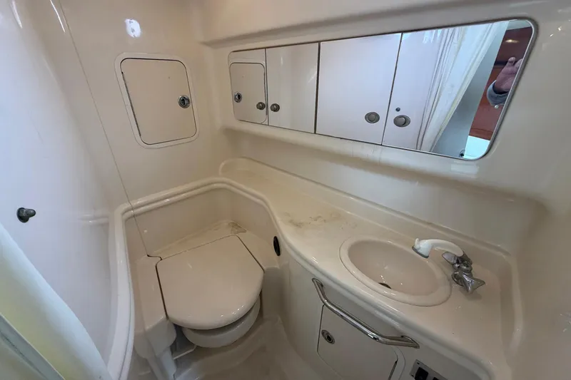 Slide: The Image of 2005 Sea Ray 320 Sundancer bathroom with toilet, sink, and mirrored cabinets. - 6