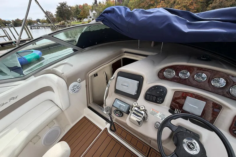 Slide: The Image of 2005 Sea Ray 320 Sundancer cockpit with steering wheel, navigation instruments, and wood accents. - 7