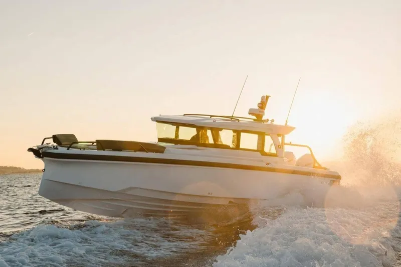 Slide: The Image of 2026 Axopar 38 Cross Cabin boat cruising at sunset on open water. - 2