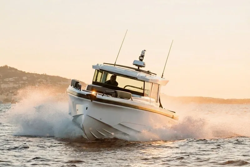 Slide: The Image of 2026 Axopar 38 Cross Cabin boat navigating through waves at sunset. - 3