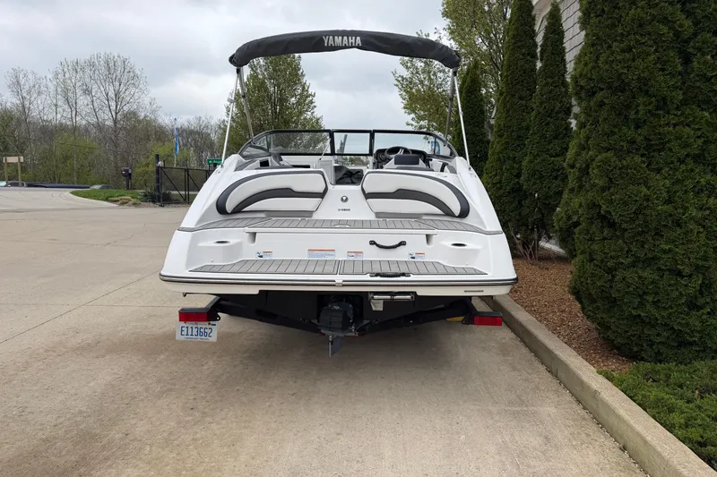 Slide: The Image of 2019 Yamaha Boats SX195 on trailer, rear view, parked near trees. - 3