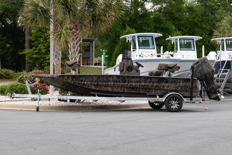 The Image of 2026 Excel 203 Bay Pro Elite boat on trailer, parked near palm trees. - 1