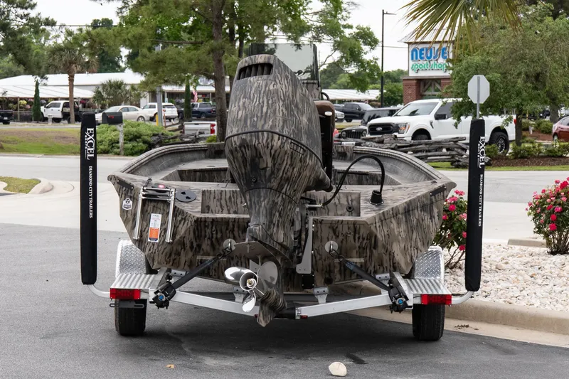 Slide: The Image of 2026 Excel 203 Bay Pro Elite boat on trailer, parked outdoors near a sport shop. - 5