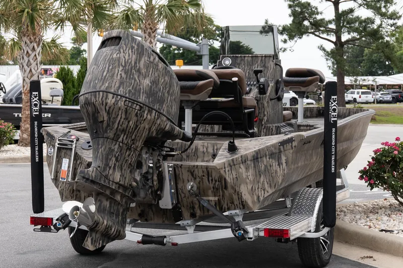 Slide: The Image of 2026 Excel 203 Bay Pro Elite boat on trailer, camo design, parked outdoors. - 6