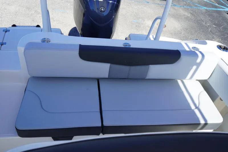 Slide: The Image of 2026 Robalo R202 Explorer boat seating area with cushioned bench and motor in background. - 11