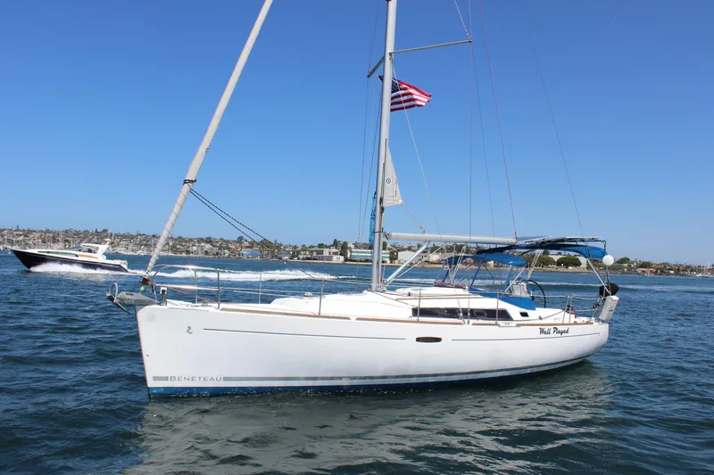 Slide: The Image of 2012 Beneteau Oceanis 37 sailboat on water, American flag flying, clear blue sky. - 10