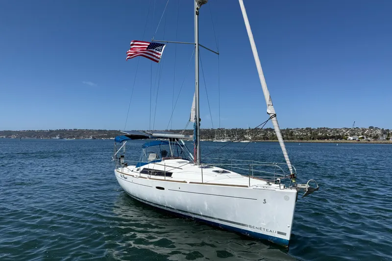 Slide: The Image of 2012 Beneteau Oceanis 37 sailboat with American flag on calm waters. - 2