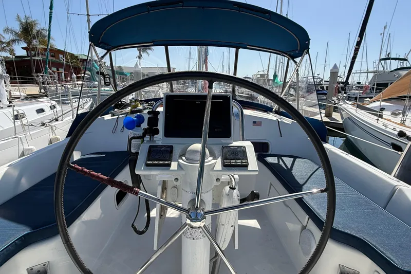 Slide: The Image of Cockpit view of a 2012 Beneteau Oceanis 37 sailboat, featuring steering wheel and navigation instruments. - 34