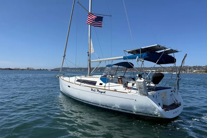 Slide: The Image of 2012 Beneteau Oceanis 37 sailboat on water, American flag, clear sky. - 8