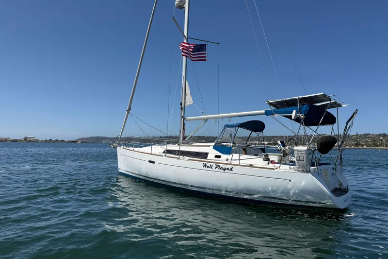 Slide: The Image of 2012 Beneteau Oceanis 37 sailboat on water, clear sky, American flag flying. - 9