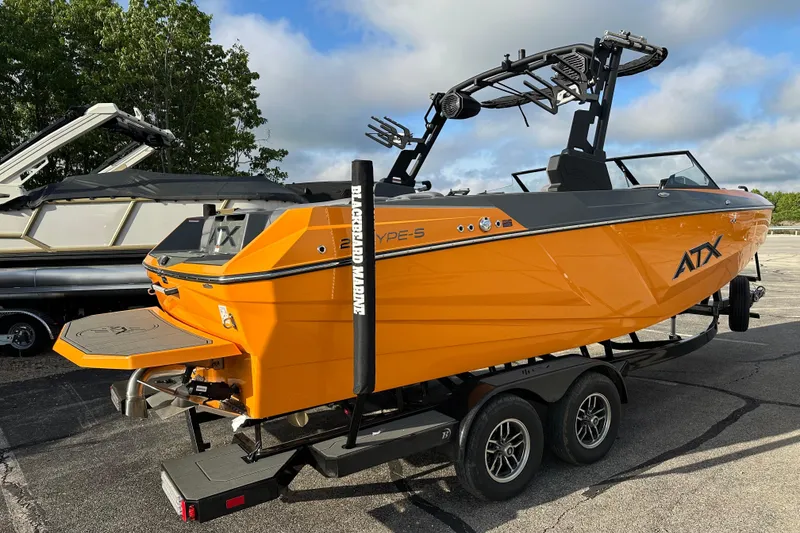 Slide: The Image of 2026 ATX Surf Boats 22 Type-S in vibrant orange on a trailer, parked outdoors. - 3