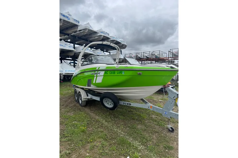 The Image of 2021 Yamaha Boats 212XD in vibrant green on a trailer, parked outdoors. - 0