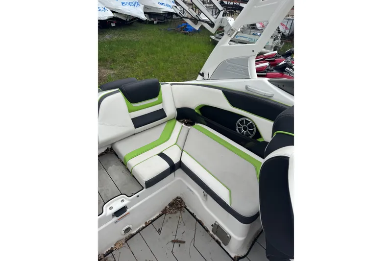Slide: The Image of 2021 Yamaha Boats 212XD interior with green and black seating, speaker, and deck view. - 11
