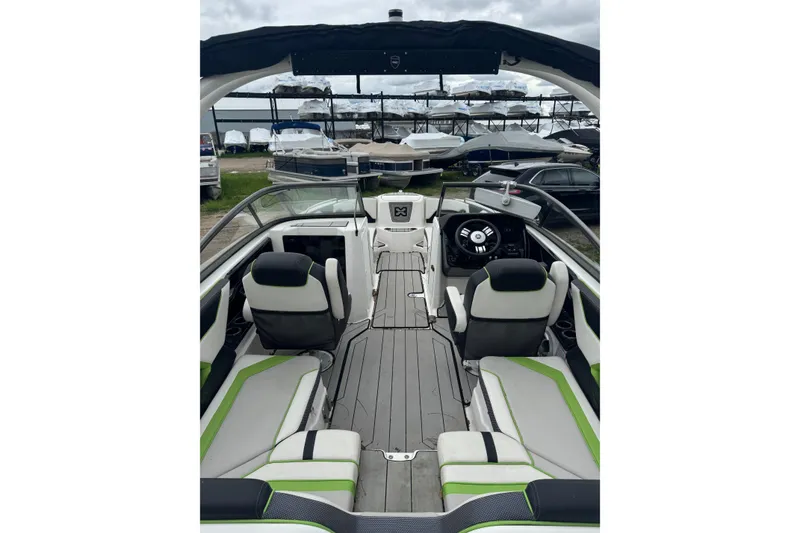 Slide: The Image of 2021 Yamaha Boats 212XD interior with modern seating and steering, docked at marina. - 3