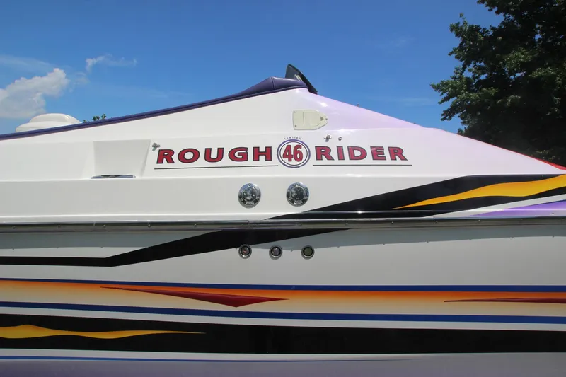 Slide: The Image of 2001 Cigarette 46 Rough Rider boat with colorful stripes and logo on the side. - 10