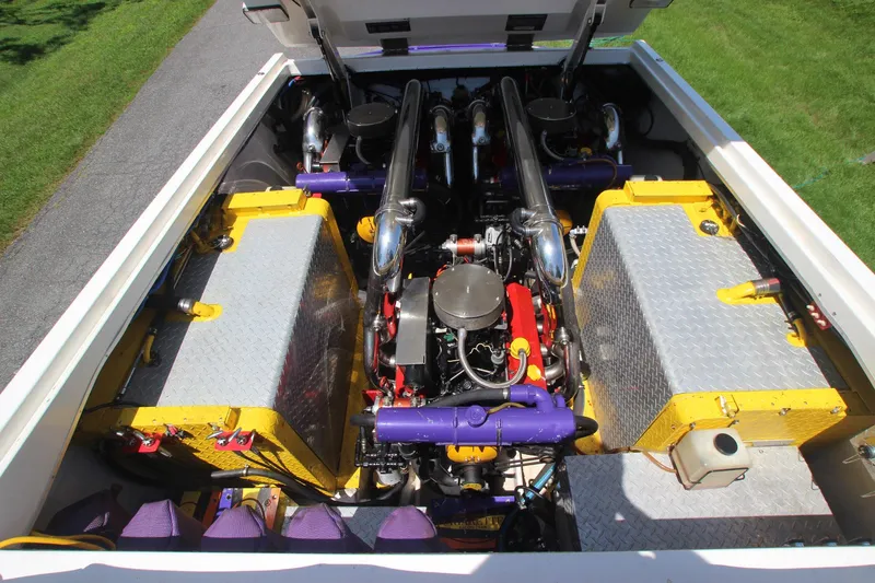 Slide: The Image of Engine compartment of a 2001 Cigarette 46 Rough Rider boat, featuring vibrant yellow and purple components. - 22