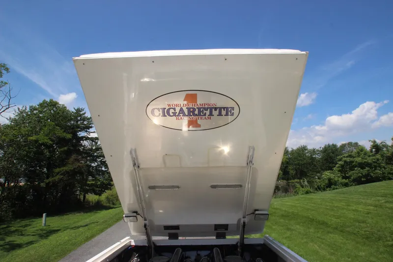 Slide: The Image of 2001 Cigarette 46 Rough Rider boat engine cover open, showcasing logo, against a clear blue sky. - 29